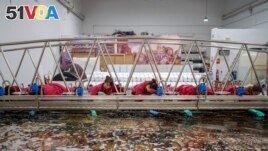 Staff workers clean a tapestry at the Royal Tapestry Factory in Madrid, Spain, Friday, Nov. 30, 2023. (AP Photo/Manu Fernandez)
