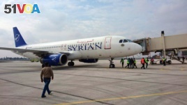 This photo released by the Syrian official news agency SANA, shows a Syrian commercial plane carrying Syrian officials and journalists after it landed at Aleppo airport, Syria, Wednesday, Feb. 19, 2020. 