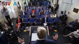 Reporters are seen complying with social distancing norms as President Donald Trump speaks about the coronavirus in the James Brady Press Briefing Room at the White House, April 13, 2020, in Washington. 