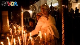 An Ethiopian woman and her child visit the Church of the Nativity, traditionally believed to be the birthplace of Jesus Christ, in the West Bank town of Bethlehem, Saturday, Dec. 3, 2022. Business in Bethlehem is returning after the pandemic. (AP Photo/ Mahmoud Illean)