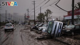 Typhoon-damaged cars sit on the street covered with mud, Oct. 14, 2019, in Hoyasu, Japan. Rescue crews dug through mudslides and searched near swollen rivers as they looked for those missing from typhoon Hagibis