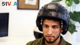 A worker at the Israeli startup Brain.Space shows an electroencephalogram (EEG) enabled helmet, due to be used in an experiment on the effects of a microgravity environment on the brain activity of astronauts, in Tel Aviv, Israel on March 23, 2022. (REUTERS/Nir Elias)