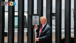 U.S. President Donald Trump prepares to autograph a plaque commemorating the construction of the 200th mile of border wall while visiting the wall on the U.S.-Mexico border in San Luis, Arizona, June 23, 2020.