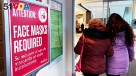 FILE - A sign announcing a face mask requirement is displayed at a hospital in Buffalo Grove, Ill., on January 13, 2023. (AP Photo/Nam Y. Huh)