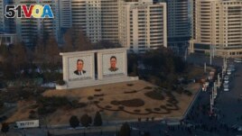 FILE - Portraits of late North Korean leaders Kim Il Sung and Kim Jong Il sit in downtown Pyongyang, North Korea.