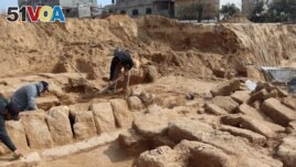 Men work in a newly discovered Roman cemetery in Gaza, in this handout photo obtained by Reuters, February 17, 2022. Ministry of Tourism and Antiquities/Handout via REUTERS 