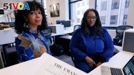 Amber Payne, left, and Deborah Douglas co-editors-in-chief of the new online publication of The Emancipator pose at their office inside the Boston Globe, Feb. 2, 2022, in Boston. (AP Photo/Charles Krupa)