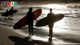 FILE - Surfers prepare to enter the water at Bondi beach near Sydney, Australia on April 28, 2020. (AP Photo/Rick Rycroft)