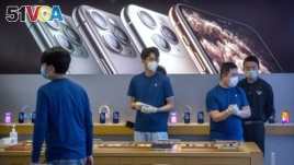 Employees wear face masks as they stand in a reopened Apple Store in Beijing, Friday, Feb. 14, 2020. China on Friday reported another sharp rise in the number of people infected with a new virus, as the death toll neared 1,400. Apple had closed all...
