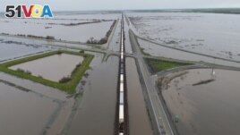 A train passes as floodwaters from the Tule River inundate the area after days of heavy rain in Corcoran, California, U.S. on March 22, 2023. (REUTERS/David Swanson)