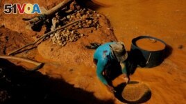 FILE - A wildcat gold miner, or garimpeiro, uses a tool and mercury to search for gold at a wildcat gold mine, also known as a garimpo, at a deforested area of the Amazon rainforest near Crepurizao, Para State, Brazil, August 5, 2017. (REUTERS/Nacho Doce/File Photo)