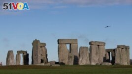 In this Tuesday, Dec. 17, 2013 file photo, visitors take photographs of the world heritage site of Stonehenge, in Wiltshire England. 