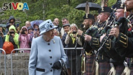 Queen Elizabeth II inspects the guard of honor before entering Balmoral Castle, Scotland, at the start of her annual holiday, Aug. 6, 2019.