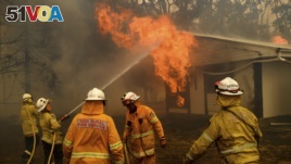 Firefighters battle the Morton Fire as it burns a home near Bundanoon, New South Wales, Australia, on Thursday, Jan. 23, 2020. (AP Photo/Noah Berger)