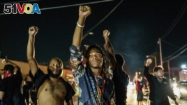 Protesters raise their fists during a demonstration against the shooting of Jacob Blake in Kenosha, Wisconsin on August 26, 2020. - Two people were shot dead and a third injured on the night of August 25 in the US city of Kenosha, Wisconsin.