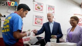 FILE - President Joe Biden, joined by Rep. Karen Bass, D, Calif., pays for a takeout order at Tacos 1986, a Mexican restaurant, in Los Angeles, Thursday, Oct. 13, 2022. (AP Photo/Carolyn Kaster)
