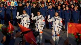 Chinese astronauts for the Shenzhou-17 mission, from left, Jiang Xinlin, Tang Hongbo and Tang Shengjie wave as they attend a send-off ceremony for their manned space mission at the Jiuquan Satellite Launch Center in northwestern China on October 26, 2023. (AP Photo/Andy Wong)