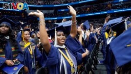 A graduate waves as students arrive Howard University's commencement in Washington, Saturday, May 13, 2023. (AP Photo/Alex Brandon)