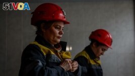 Nataliia, 43-years-old, and Krystyna, 22-years-old, dress in uniforms before going down to work their shift underground, amid Russia's attack on Ukraine, at a mine in Dnipropetrovsk region, Ukraine on November 17, 2023. (REUTERS/Alina Smutko)