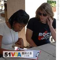 A Rock the Vote worker helping to register a young voter