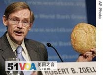 World Bank President Robert Zoellick holds up bread as he speaks to reporters