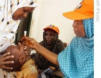 A W.H.O. official gives polio vaccine to a child in Mogadishu, Somalia, in 2006