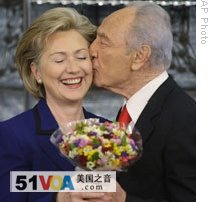 Hillary Clinton gets flowers and a kiss from Israeli President Shimon Peres in Jerusalem on Tuesday