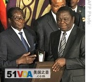 Zimbabwe President Robert Mugabe, left, and new Prime Minister Morgan Tsvangirai pose after signing the power-sharing accord, 15 Sept 2008