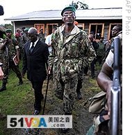 Rebel General Laurent Nkunda (C) walks in the courtyard of a house after speaking with the press in the town of Kitshoumba, 02 Nov 2008 
