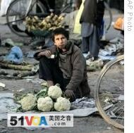 An Afghan boy waits for customer as he sells vegetables in Kabul, Afghanistan, 24 Nov 2008