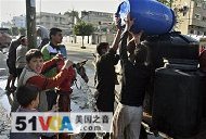 Palestinians collect water during a three-hour break in the twelve-day Israeli bombardment of Gaza City, Wednesday, 07 Jan. 2009