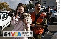 An Israeli woman, suffering from shock, is helped by a soldier after a rocket fired from the Gaza Strip hit the southern town of Sderot, Sunday, 11 Jan. 2009