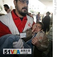 A Palestinian man carries a wounded boy into Gaza City's al-Shifa hospital, 06 Jan 2009