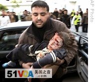 A Palestinian man carries a child, wounded in the Israeli military operation, into the hospital of the northern Gaza Strip town of Beit Lahiya, 11 Jan 2009
