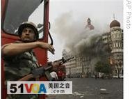 An Indian soldier takes cover as the Taj Mahal hotel in Mumbai burns during a gun battle between the Indian military and militants in November