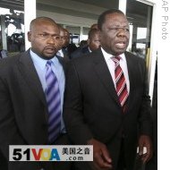 Morgan Tsvangirai (r), leader of the main opposition party in Zimbabwe is flanked by bodyguards upon his arrival at Harare International Airport, 17 Jan 2009