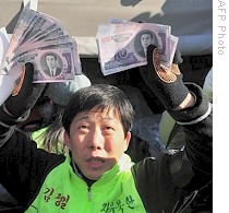 Park Sang-hak, who heads group of North Korean defectors, shows North Korean banknotes before launching balloons carrying them over border, 16 Feb 2009