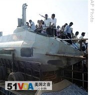 Sri Lankans climb on recently seized Tamil Tiger submarine-type craft on display at state exhibition in Colombo, 05 Feb 2009