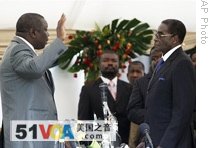 Morgan Tsvangirai (l) leader of the main opposition party in Zimbabwe takes the oath of Prime Minster, in front of President Robert Mugabe (r) at the State House in Harare, 11 Feb 2009
