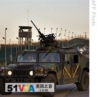 Soldiers in a Humvee patrol the perimeter of the Camp Delta detention compound, at Guantanamo Bay's US Naval Base, in Cuba, 06 Jun 2008
