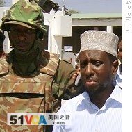 African Union peacekeeper (l) stands guard for Somali President Sheikh Sharif Sheikh Ahmed (r) in Mogadishu, 09 Feb 2009 