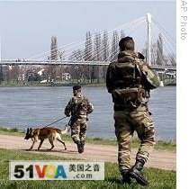 French soldiers walk along the bridge between France and Germany that will host official picture of forthcoming NATO meeting, 30 Mar 2009