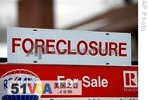 A foreclosure sign sits on top of a sale placard outside a home on the market in the south Denver suburb of Littleton, Colorado, 23 Dec 2008