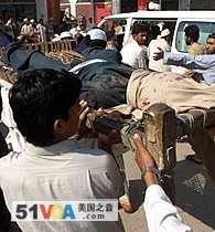 Pakistani people carry a suicide blast victims body on a local bed outside a hospital in Peshawar, 27 Mar 2009