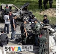Thai police officers and soldiers examine the wreckage of cars that was exploded after insurgents detonated a bomb hidden inside in Narathiwat province, southern Thailand, 04 Nov 2008