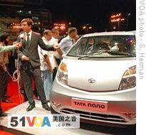 A Tata Motor official is interviewed by Indian TV next to the Nano at the launch event