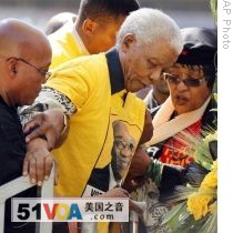 Former S. African President Nelson Mandela, center, is helped by Jacob Zuma, left and Mandela's former wife Winnie, in Johannesburg, S. Africa, 19 Apr 2009