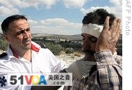 A medic attends a Palestinian farmer after Jewish settlers from a nearby settlement in the northern West Bank allegedly attacked him as he harvested olives on October 11, 2008.