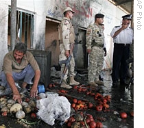 A merchant collects vegetables after a bomb explosion at a market in Baghdad's Dora neighborhood, 01  Jun 2009