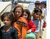Displaced children from Pakistan's Swat Valley wait to receive food at Shiekh Yasin camp in Mardan, 03 Jun  2009